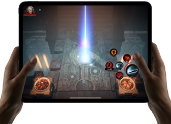 Two hands holding iPad Pro, displaying game with on screen touch controls and advanced graphics